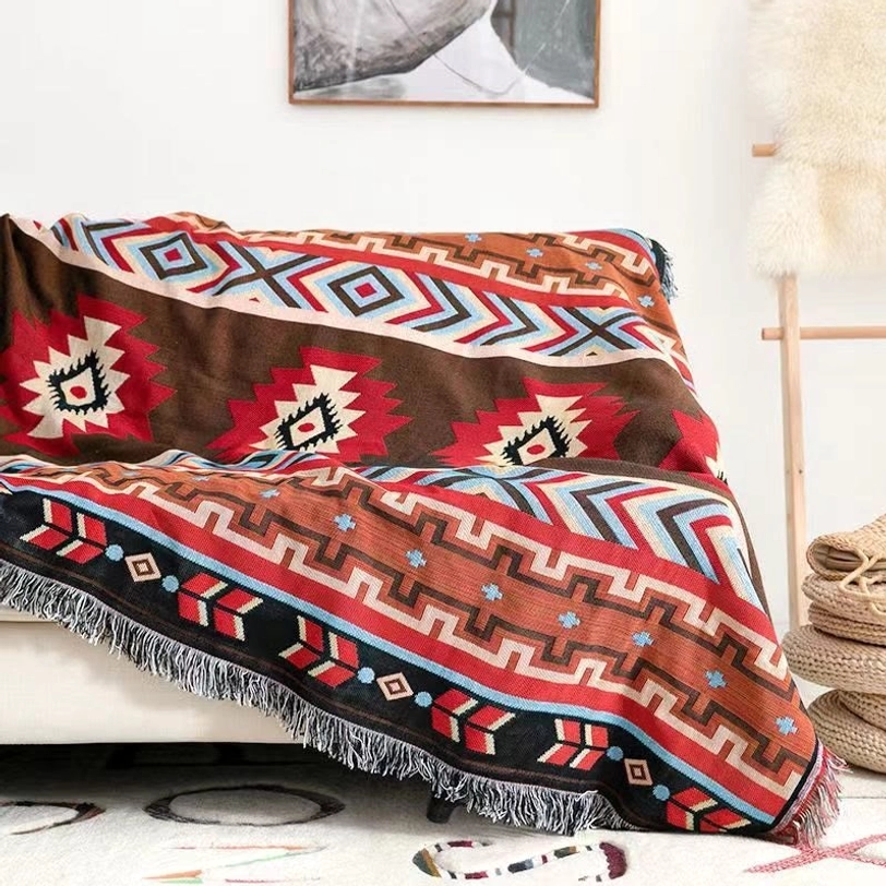 Tibetan geometric throw blanket draped over minimalist sofa showing fringed edges retro ethnic prints home décor