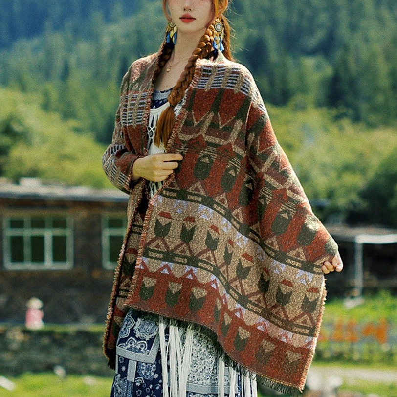 Oversized Tibetan tribal poncho scarf with loose draped fit, multi-layer geometric prints and thick cozy fabric in forest village setting