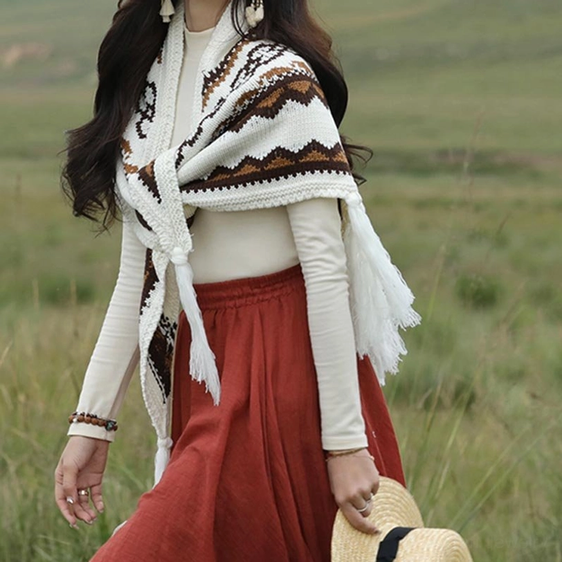 Walking action shot of woman wearing tribal knit Tibetan shawl with front tie and hanging side tassels