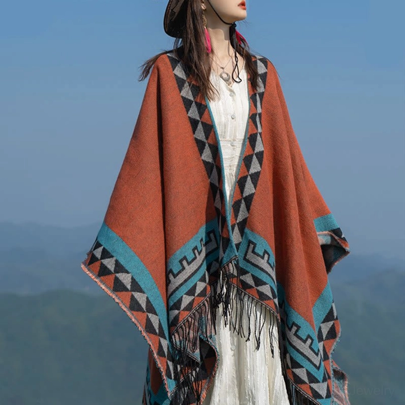 Right front three-quarter view of tribal patterned tassel shawl featuring terracotta main color with blue-grey geometric motifs and fringe