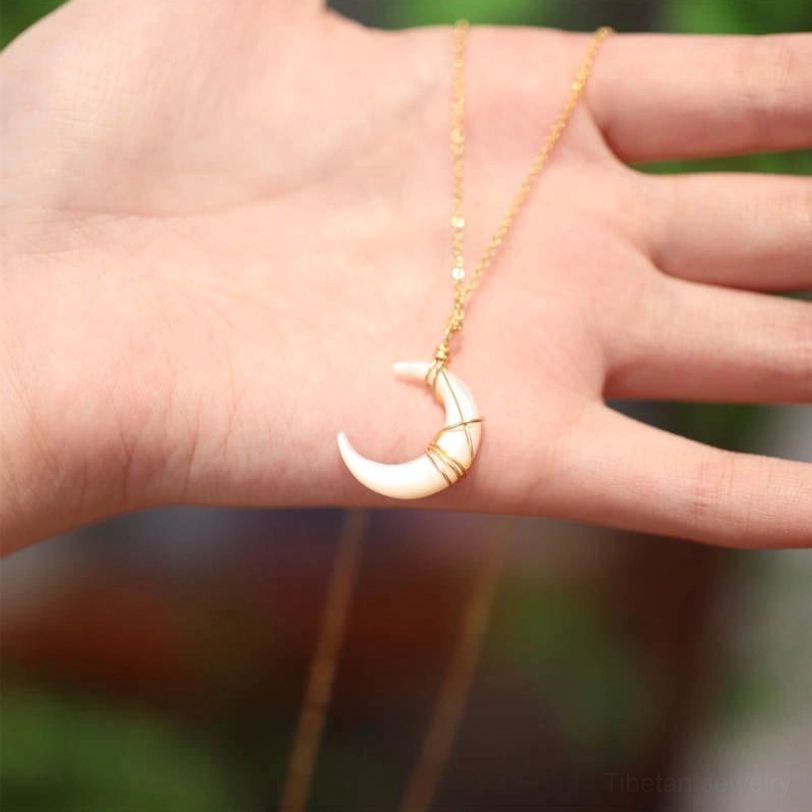 Large Tridacna crescent moon pendant close-up showing iridescent white shell and intricate gold wire wrapping