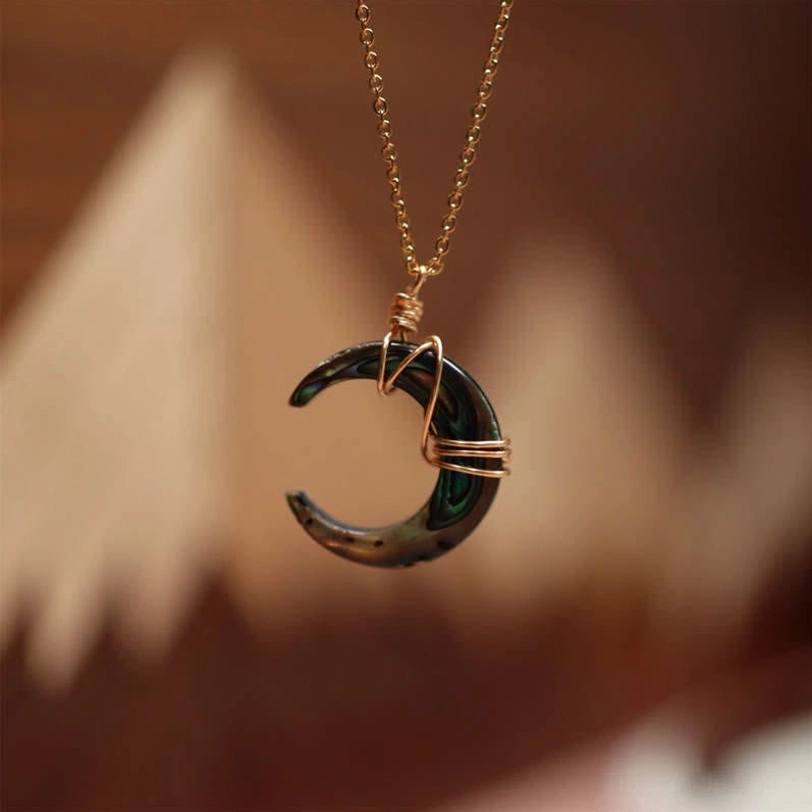 Black Tibetan Tridacna crescent moon pendant necklace with gold chain and wire wrapping, spiritual protection jewelry