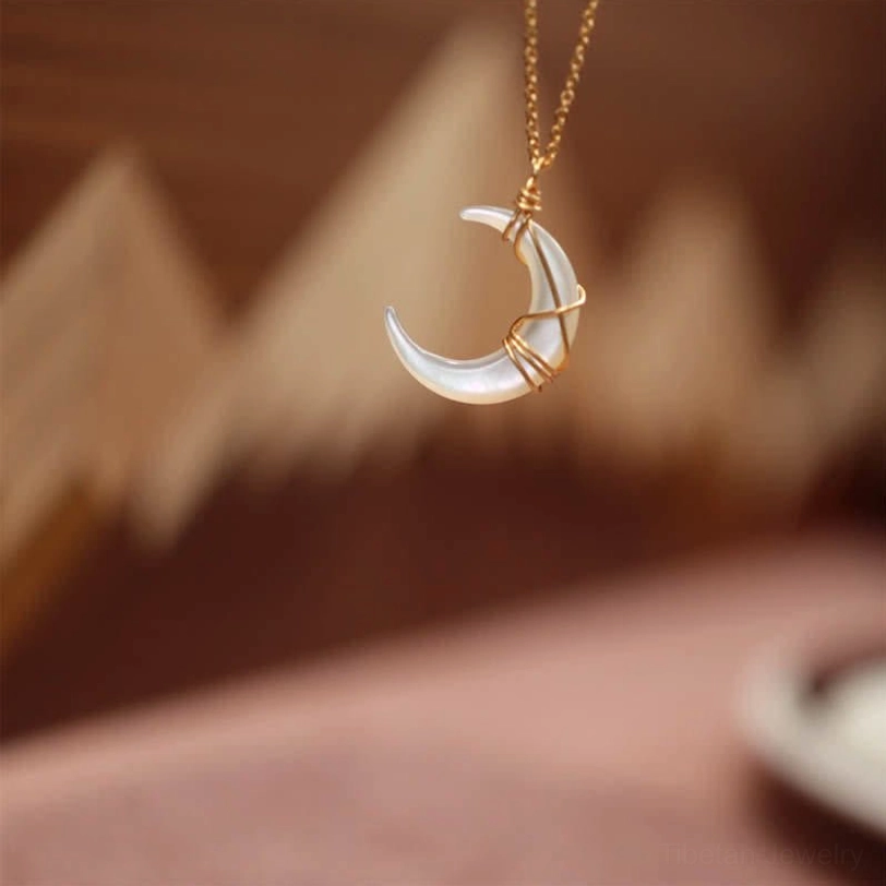 Medium Tridacna stone crescent pendant necklace overhead close-up with gold cable chain, natural lighting