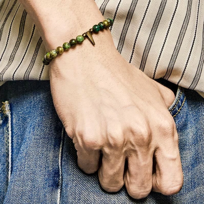 Turquoise copper bracelet worn on wrist - relaxed casual aesthetic with denim background