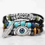 Tibetan turquoise evil eye leather bracelet front view with layered straps feather charm and filigree accents