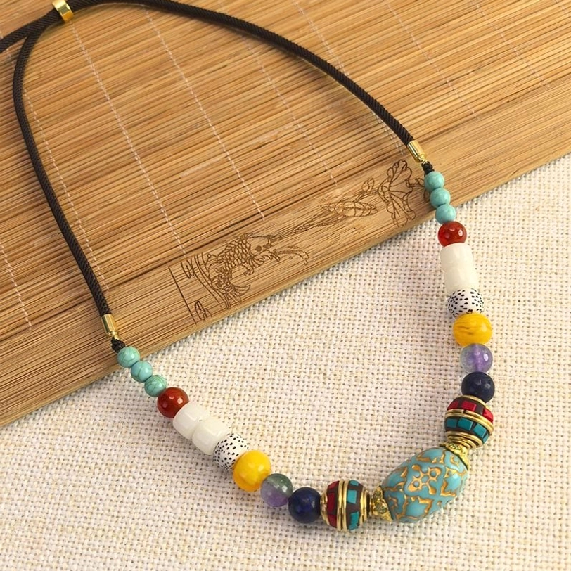 Handmade Tibetan turquoise beaded necklace on bamboo mat showing detailed bead pattern and craftsmanship