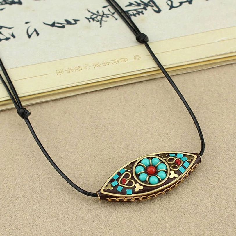 Tibetan turquoise necklace side view displaying intricate ethnic enamel work and adjustable waxed cord