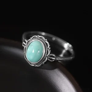 Vintage-style tibetan turquoise ring with carved silver setting, side profile view showing oval stone cabochon