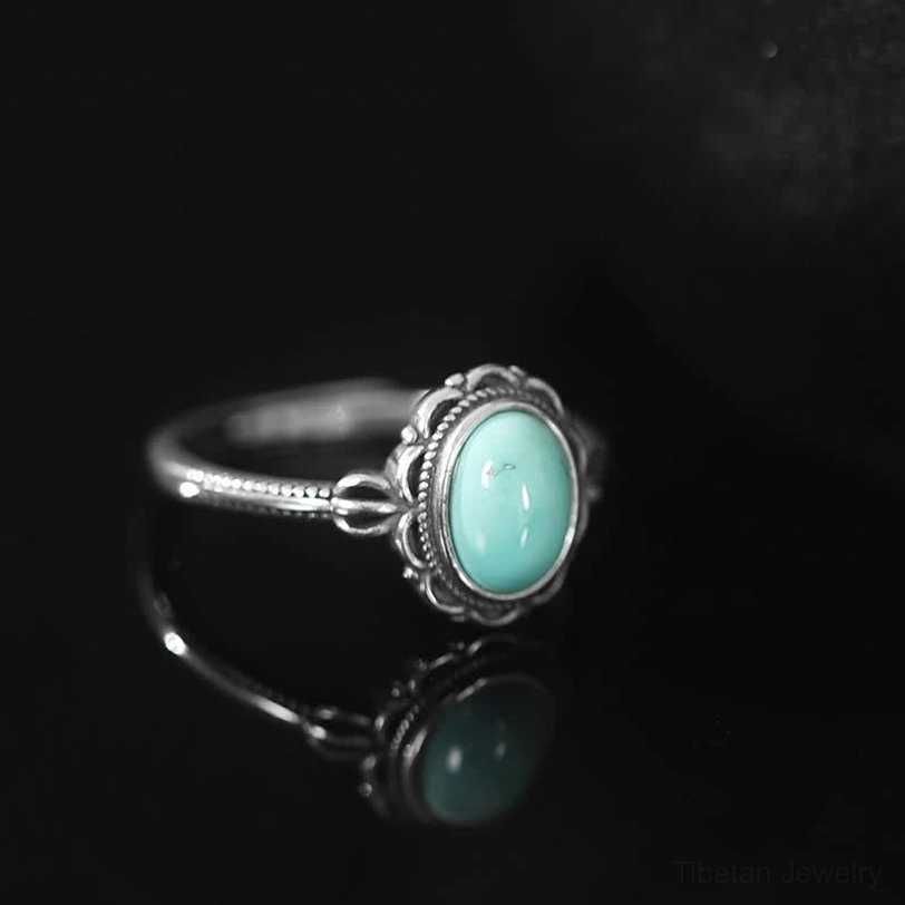 Tibetan turquoise protection ring three-quarter view showcasing intricate silver band design and natural stone
