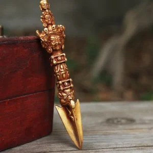 Handcrafted Tibetan copper vajra dorje with five-pronged design displayed on wooden surface with red Nepalese decorative box