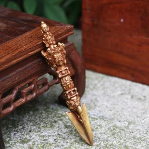 Close-up three-quarter view of authentic Nepal handmade copper vajra dorje showing intricate deity carvings and handle details
