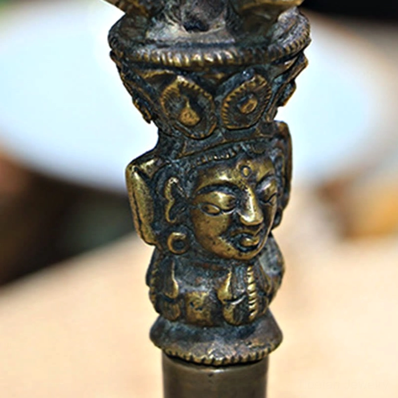 Vajra dorje close-up showing five-pronged multi-pronged design with antique bronze copper finish and religious carved motifs