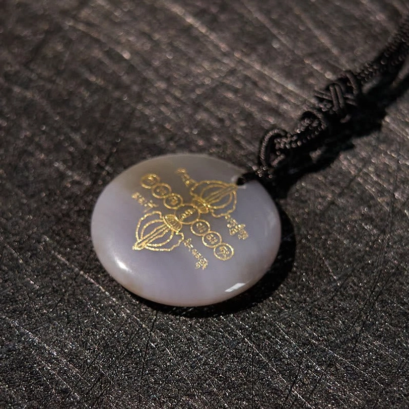 Tibetan Vajra Dorje necklace pendant natural stone with intricate golden Buddhist pattern carvings