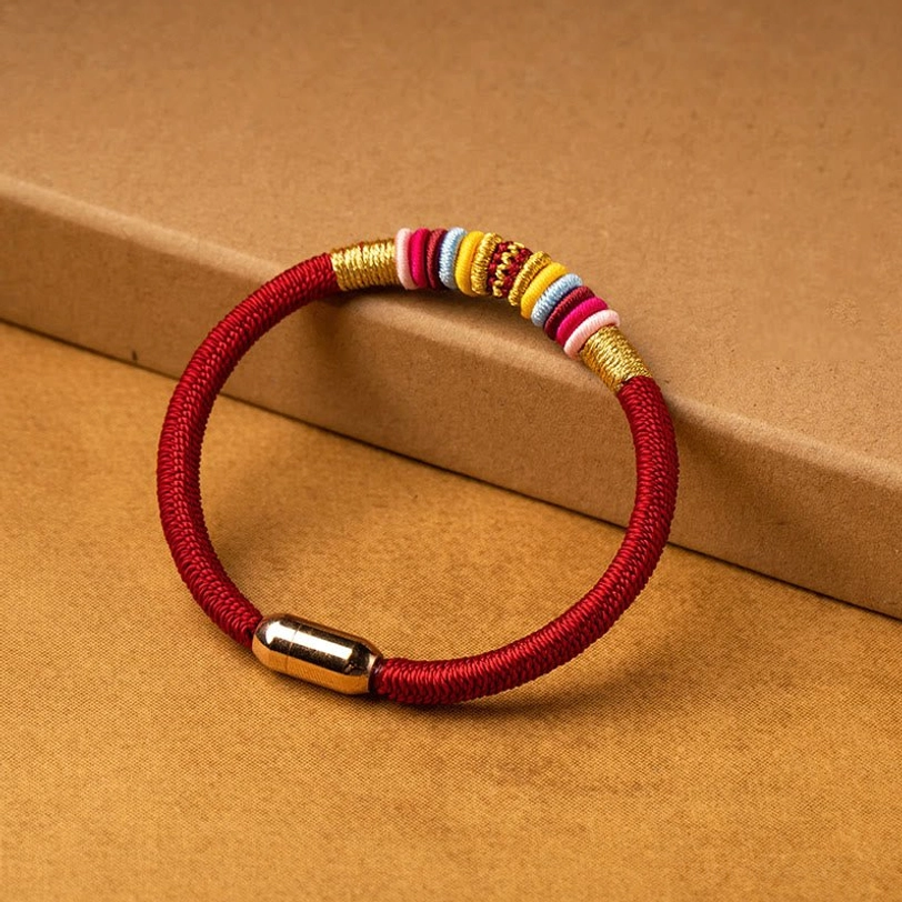 Single red woven Tibetan protection bracelet with colorful decorative wraps and magnetic metal buckle, side view