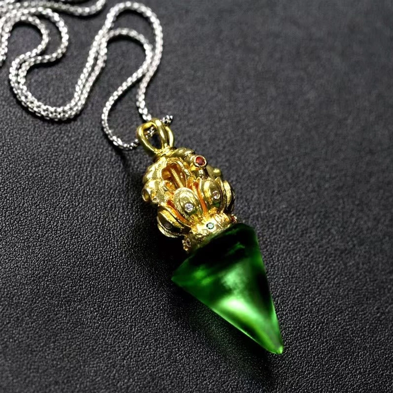 Green Tibetan Vajra crystal pendant necklace angled top view on dark background