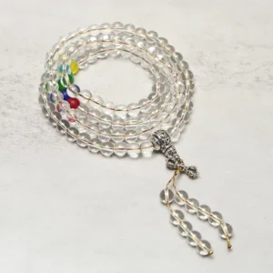 Coiled Tibetan Vajra mala with silver vajra tassel pendant and colorful chakra spacer beads close-up