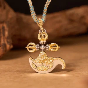 Front view of copper vajra axe pendant necklace featuring five-pronged vajra top ornament with mixed gold and silver finish and woven braided cord on dark wooden block background