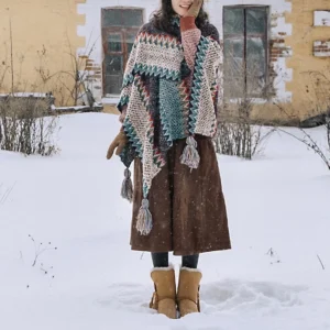 Blue beige red Tibetan knit shawl with tassel trim worn as high collar poncho in snowy rural setting
