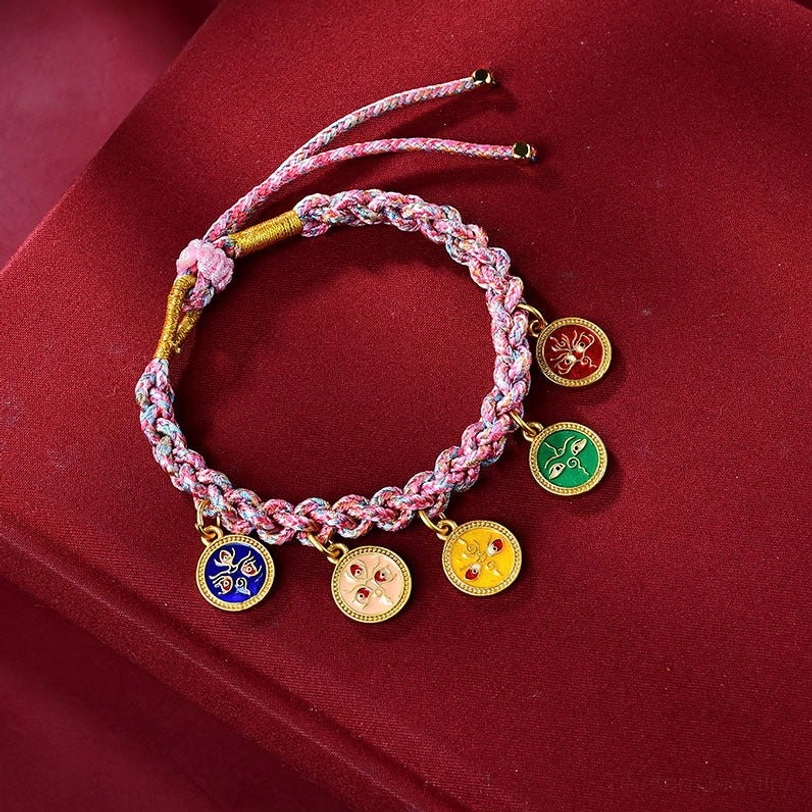 Pink-purple Tibetan braided lucky bracelet with five gods of wealth enamel charms and gold trim on red background