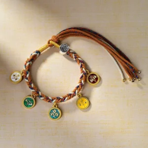 Tibetan multicolored rope wealth bracelet side angle showing detailed enamel metal pendants and adjustable drawstring tassels