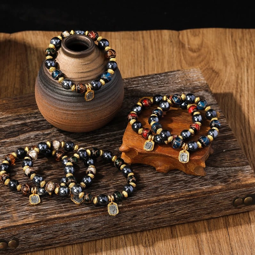 Multiple Tibetan wealth bracelets with blue green and multicolored liuli glass beads arranged on wooden tabletop display