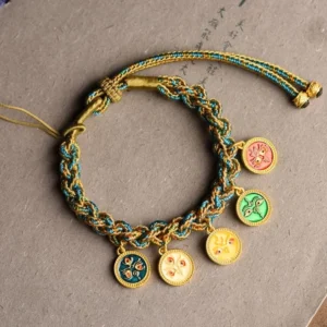 Multi-color enamel charm bracelet with adjustable pull cord, overhead view on grey background showing all five wealth deity pendants