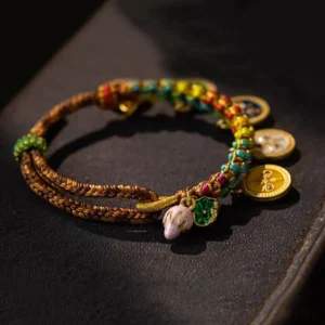 Close-up detail of five gods of wealth fortune bracelet showing braided rope sections and hanging round enamel pendants
