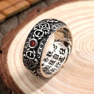 Tibetan copper ruby wealth ring adjustable band 3/4 side view showing engraved Buddhist scriptures and red gemstone on vintage silver finish