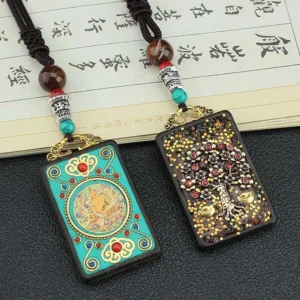 Two Tibetan Five Gods of Wealth thangka pendants showing turquoise enamel design and gold money tree decoration with brown beaded rope necklace on vintage paper