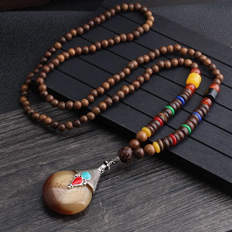 Wenge wood beaded necklace with horn-like pendant, silver tone connector, and ethnic style accents