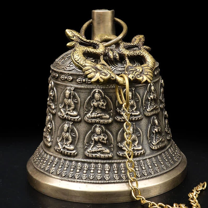Detailed embossed Buddha figure on vintage bronze wind chime bell with ritual implement