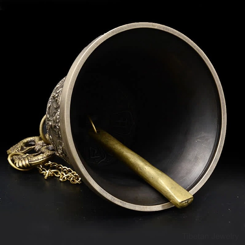 Interior view of handmade wind chime bell showing Sanskrit mantra engraving and brass clapper
