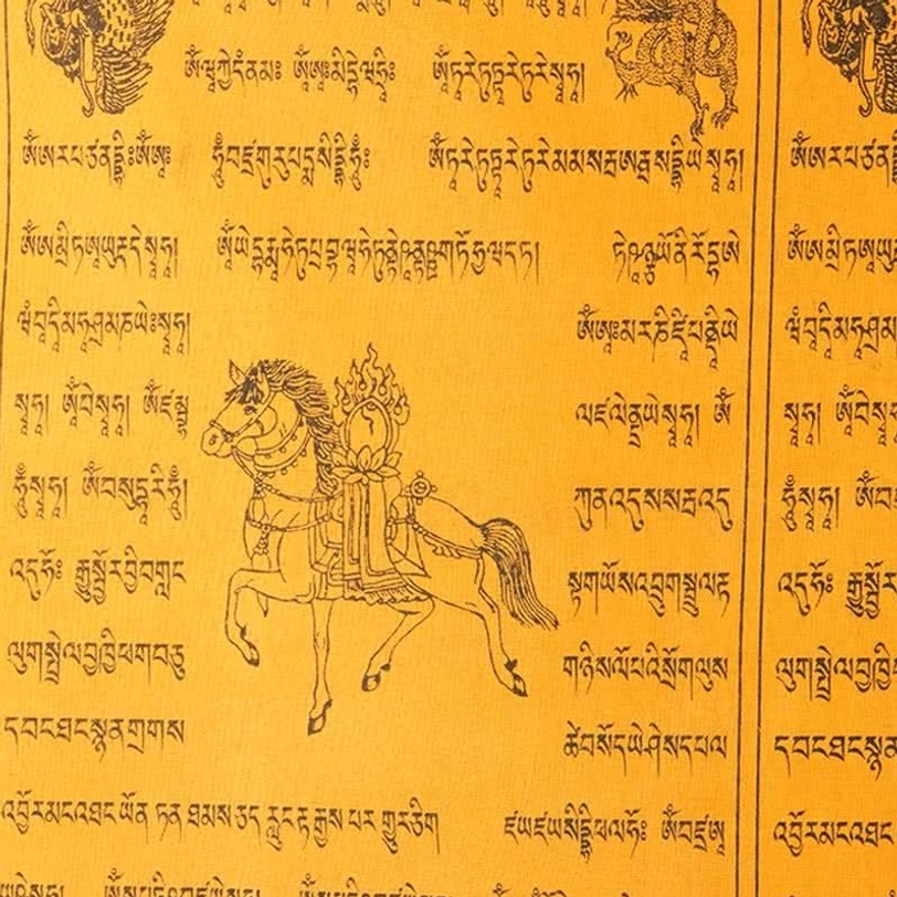 Detailed view of Tibetan prayer flag featuring orange fabric with hand-printed black wind horse and full Tibetan Buddhist mantras on artisan paper