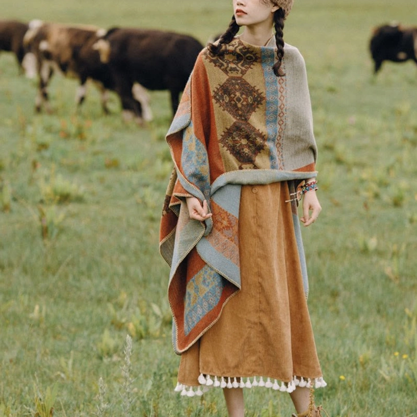 Winter poncho scarf three-quarter front full body view with chest diamond tribal print and cozy woven fabric by cattle grazing grassland