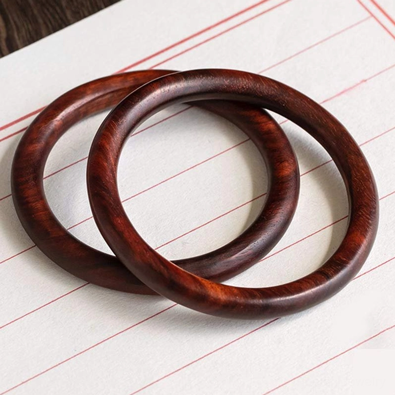 Pair of interlocked Tibetan wood protection bracelets in dark ebony and sandalwood, handcrafted bangle set with slim round design