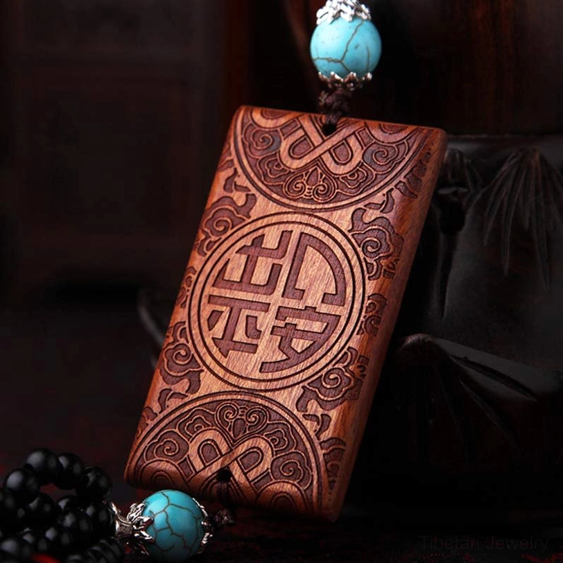 Chinese blessing character wood hanging with carved floral patterns and dark fabric background