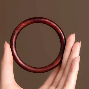 Tibetan triple wood protection bracelet handcrafted from red sandalwood, ebony and green sandalwood, showing deep reddish-brown polished finish with smooth grain