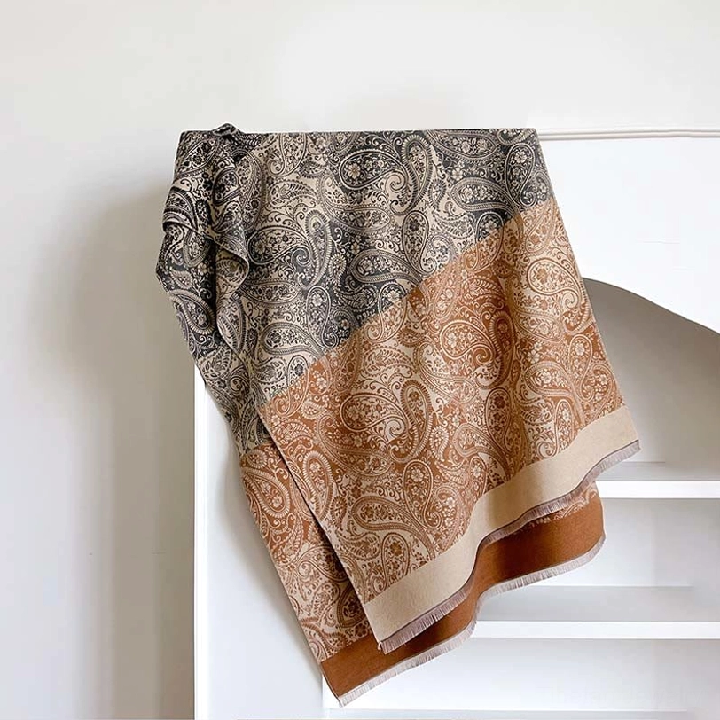 Bisque Tibetan paisley pattern scarf flat lay on white shelf, showing grey-tan-brown color block with light beige hem trim