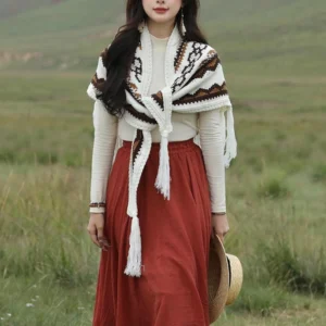 Woman wearing fringed Tibetan wrap shawl with front tie detail and hanging front tassels in grassland setting