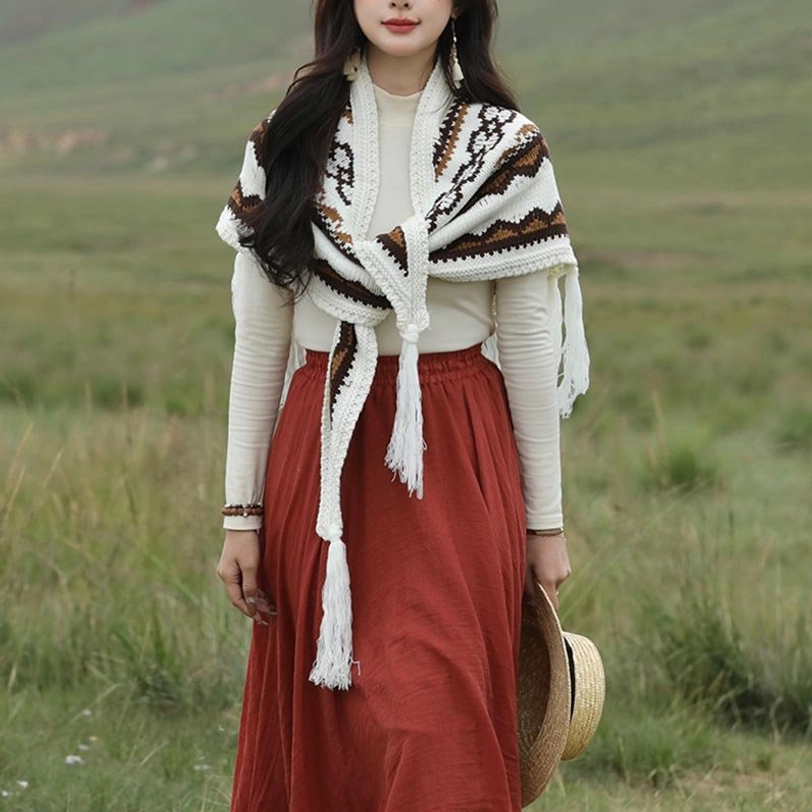 Woman wearing fringed Tibetan wrap shawl with front tie detail and hanging front tassels in grassland setting