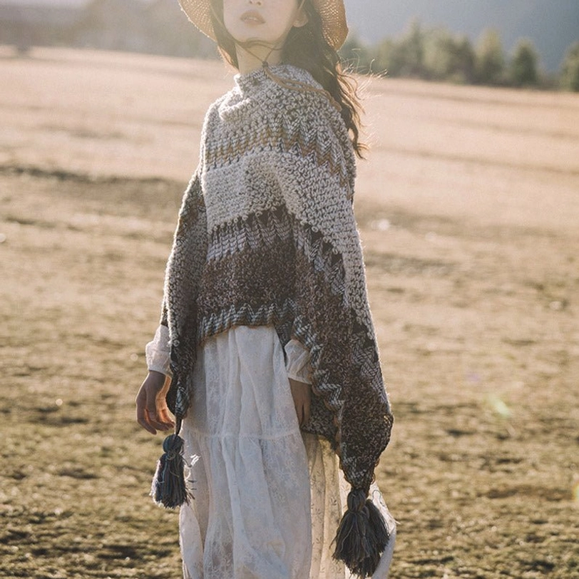 Full-body right side view of Tibetan striped wrap shawl with hanging hem tassels in natural grassland landscape