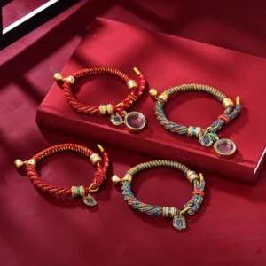 Set of two Tibetan handwoven amulet bracelets featuring red and multicolored braided cords with matching gold Zakiram goddess charms and scripture tags