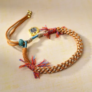 Adjustable Tibetan protection bracelet with tassel detail, braided cord structure, and metal accessories - top-down side angle