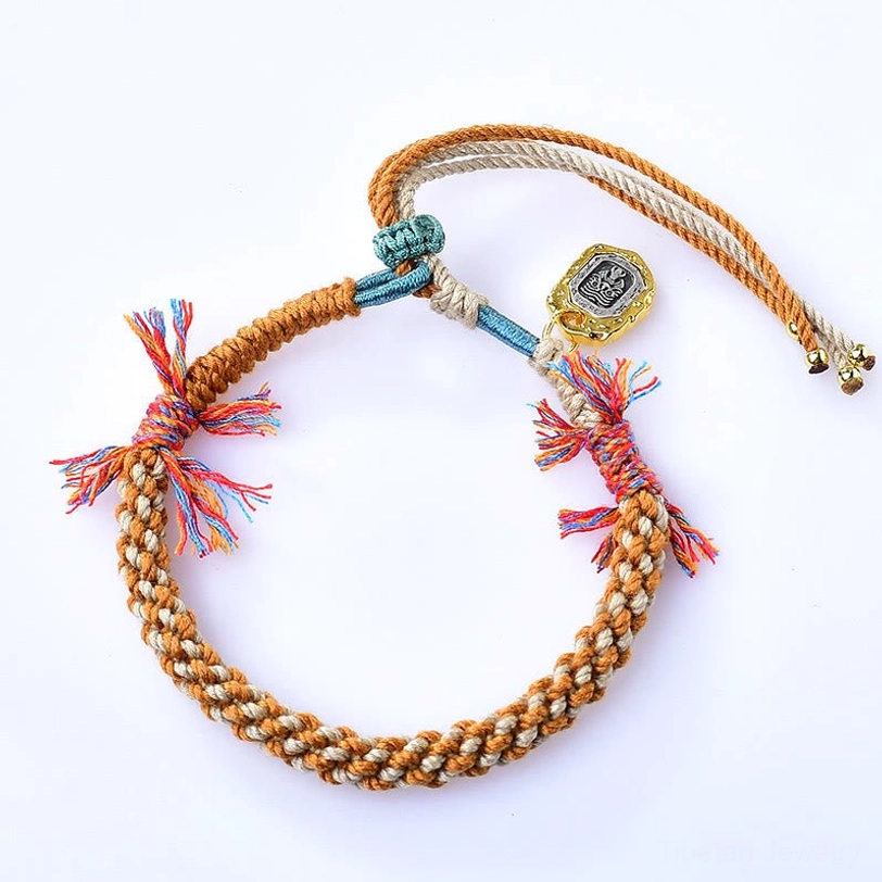Tibetan woven Zakiram goddess bracelet featuring adjustable cord design with metal pendant and traditional sacred colors