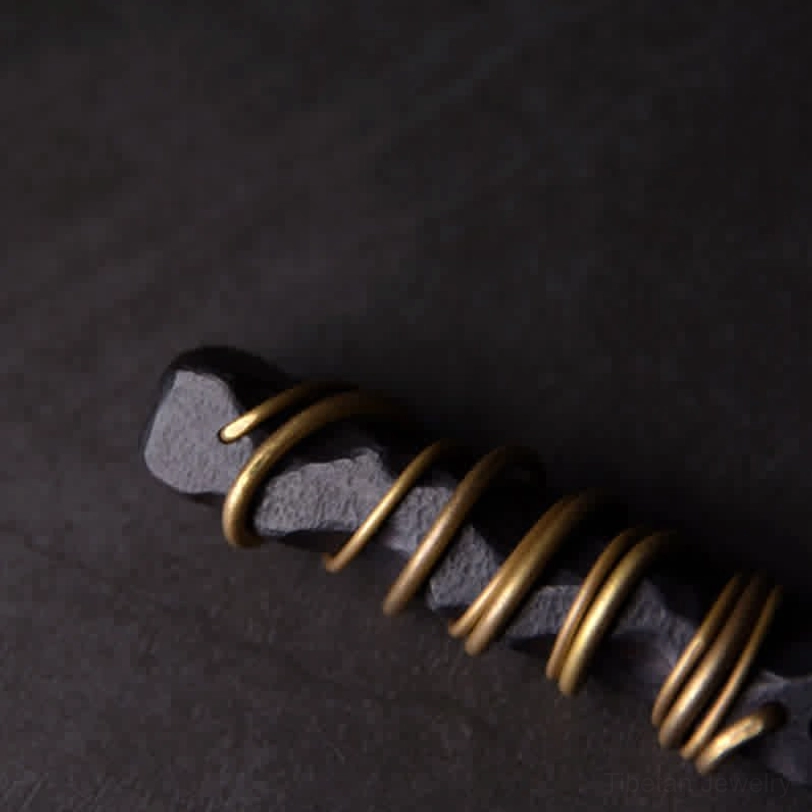 Side profile of handcrafted Tibetan ebony wood pendant with faceted natural wood and brass wire layers