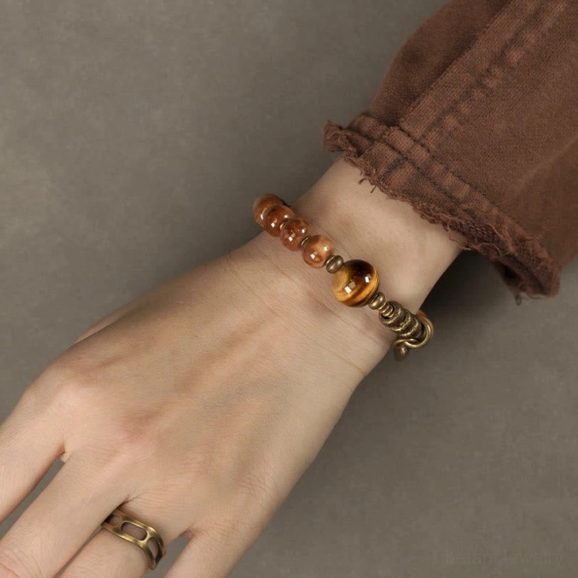 Beaded bracelet on hand with matching finger ring, tiger eye accent and brass clasp detail