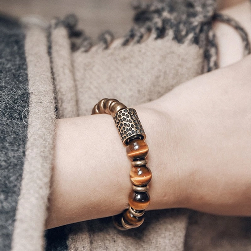 Tiger eye stone copper bracelet close-up on wrist, showing stacked beads and detailed hammered metal accent
