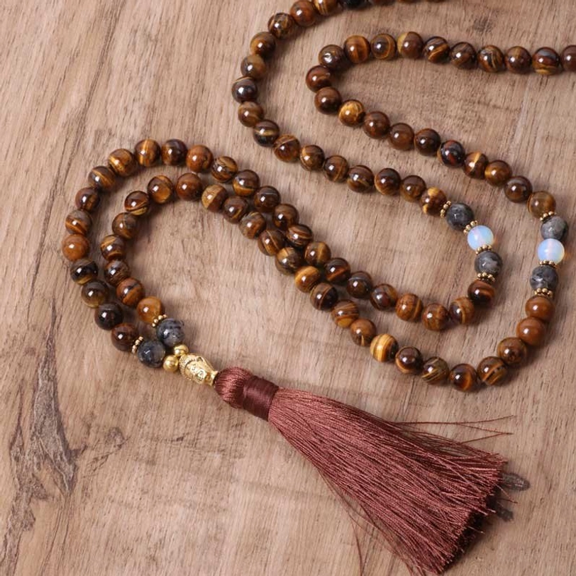 Tiger eye Buddha tassel necklace laid out showing full strand and deep red tassel
