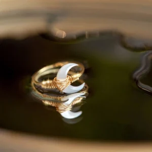 White Tridacna crescent moon 14K gold blessing ring top-down view showing natural shell inlay and twisted metal wrapping detail