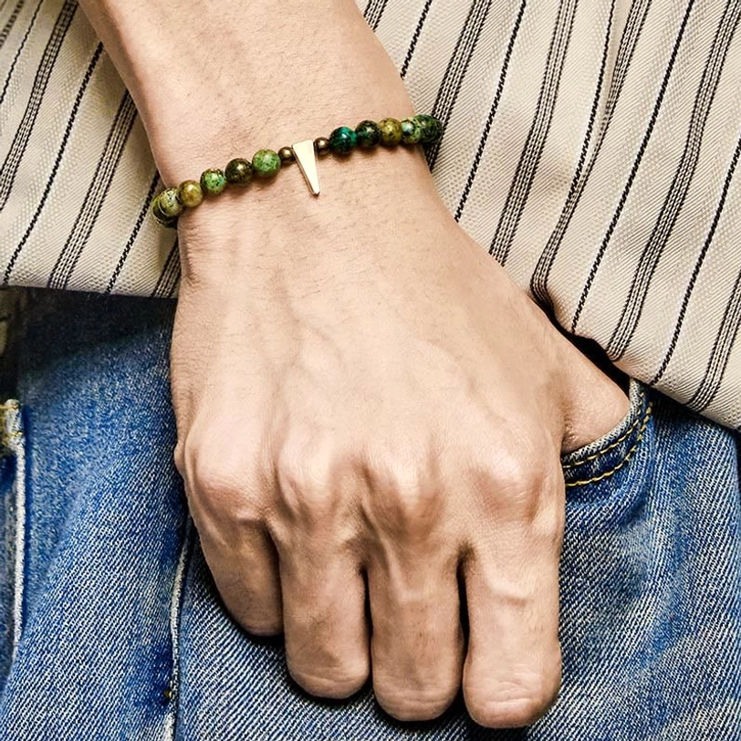 Close-up side view of turquoise copper spike bracelet fitted on wrist with centered copper pendant